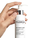 Hand holding a Filorga AGE-PURIFYCLEAN on a white background