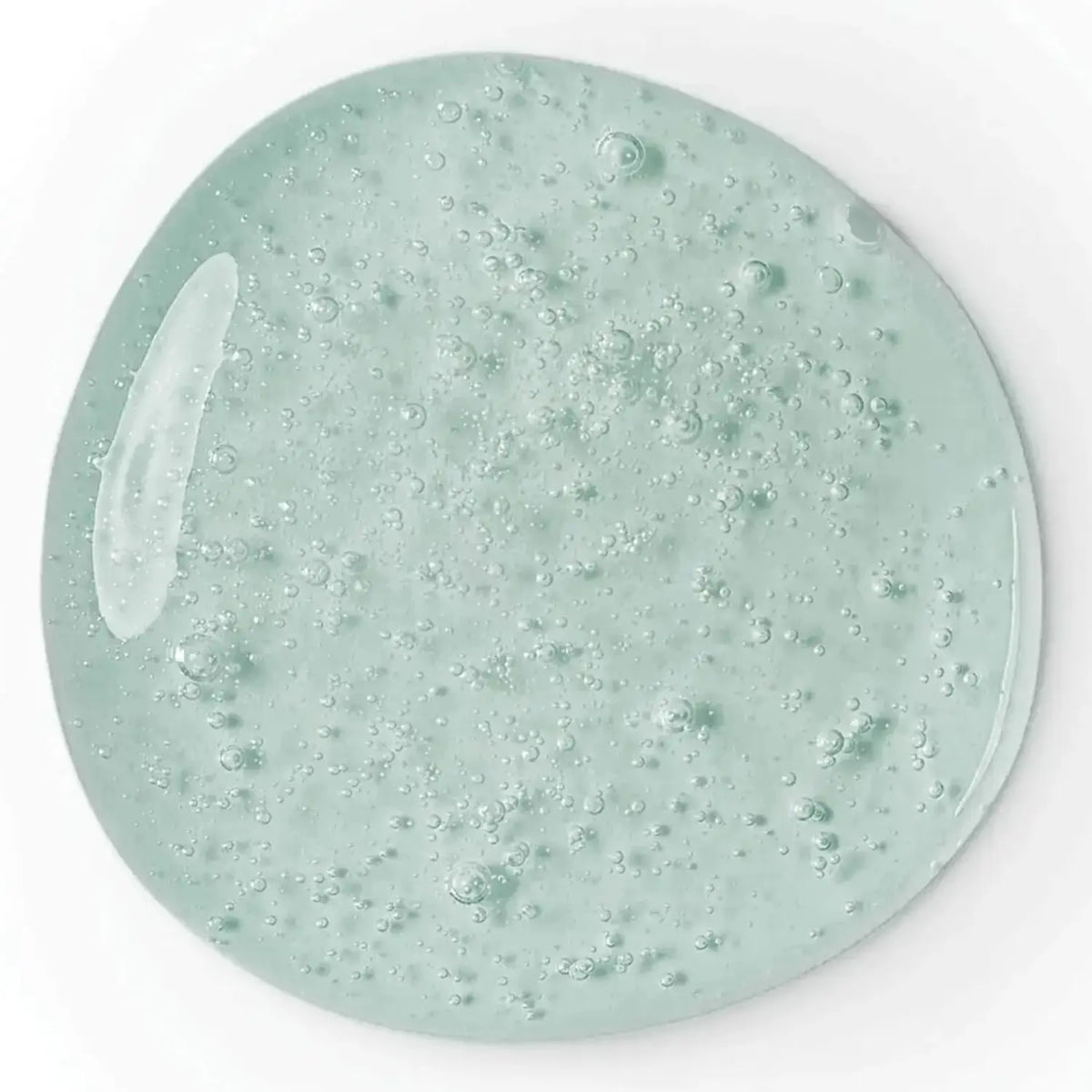Close-up of a light green gel with bubbles on a white background