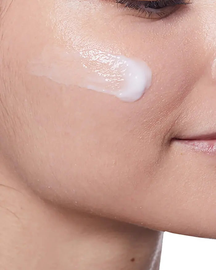 Close-up of a person applying cream to their face
