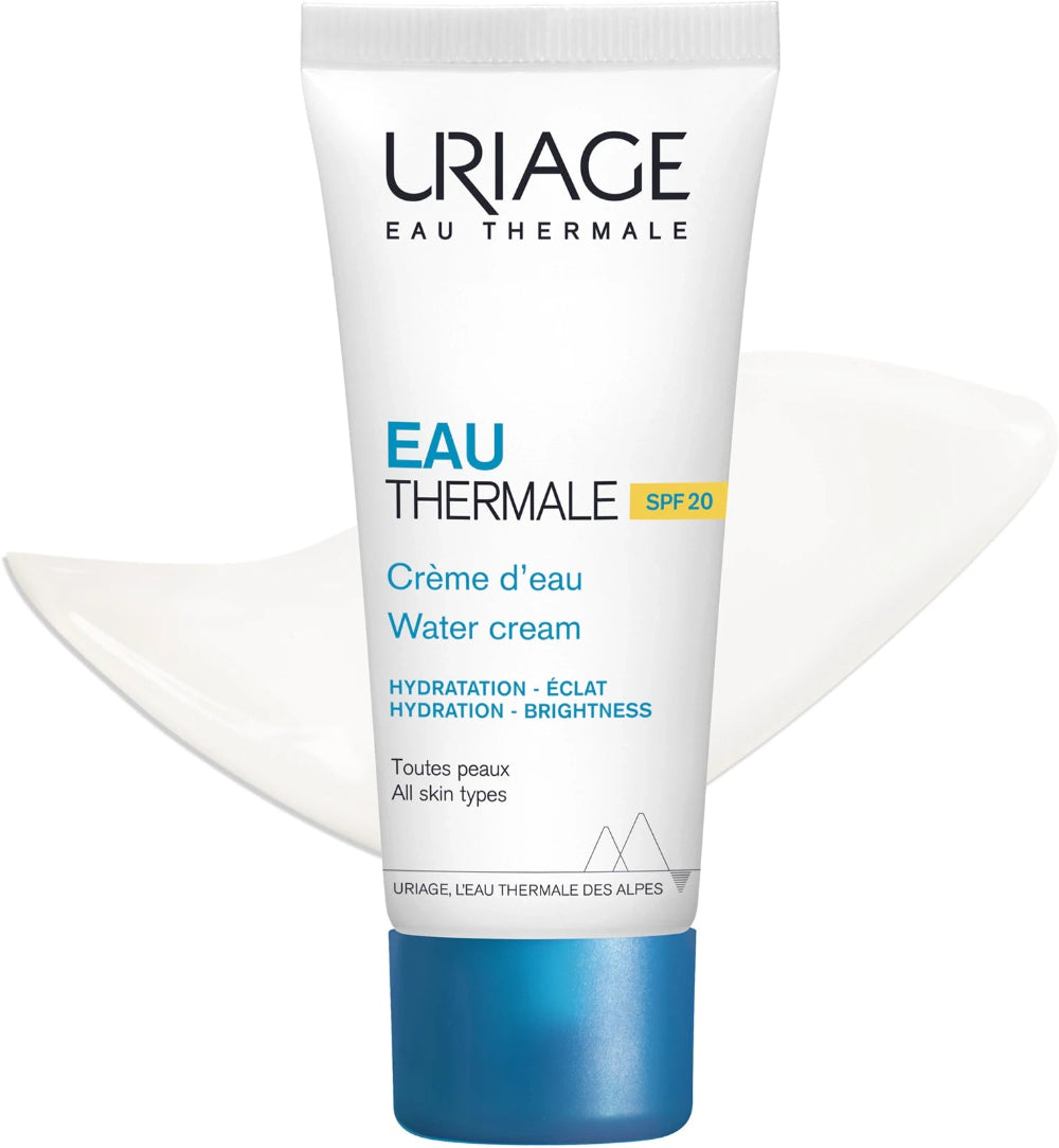 A white tube of Uriage Eau Thermale Water cream with a blue cap, shown against a white background with a subtle white wave graphic behind it.