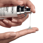 Hand holding a skincare serum bottle with dropper, showing product on finger