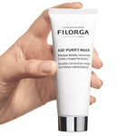 Hand holding a Filorga age-purify mask tube against a white background