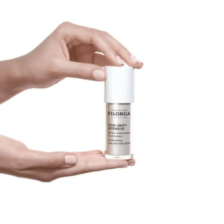Hand holding Filorga SKIN-UNIFYINTENSIVE against a white background