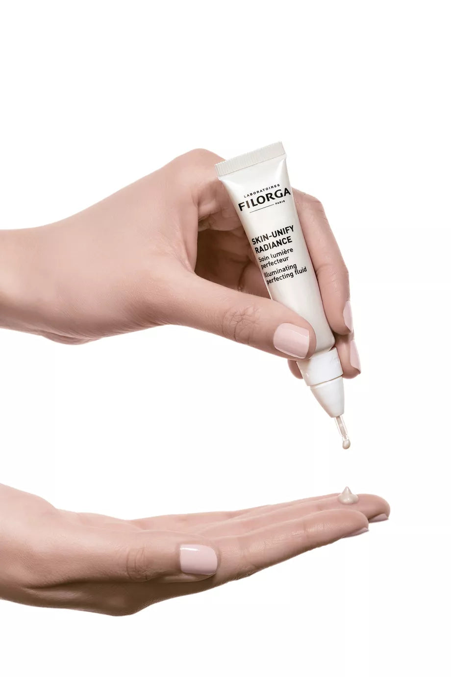 Hand holding a tube of Filorga SKIN-UNIFY RADIANCE Illuminating Even Skin Tone Face Serum
