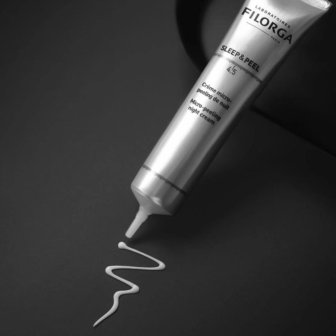 Filorga skincare tube with a wavy line of cream on a dark background