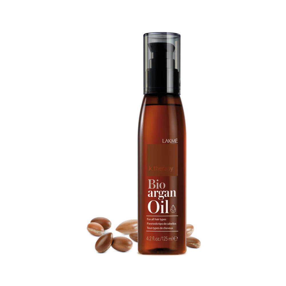 Bottle of Bio argan oil with argan seeds on a white background