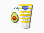 Mustela sunscreen tube with avocado on a white background