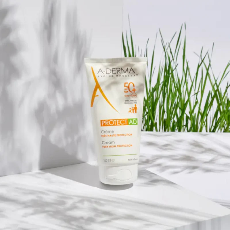 Aderma Protect AD cream tube on a white surface with grass in the background