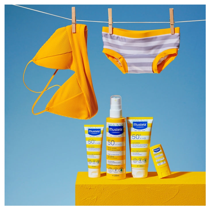 Mustela sunscreen products with yellow bikini and hat on a blue background